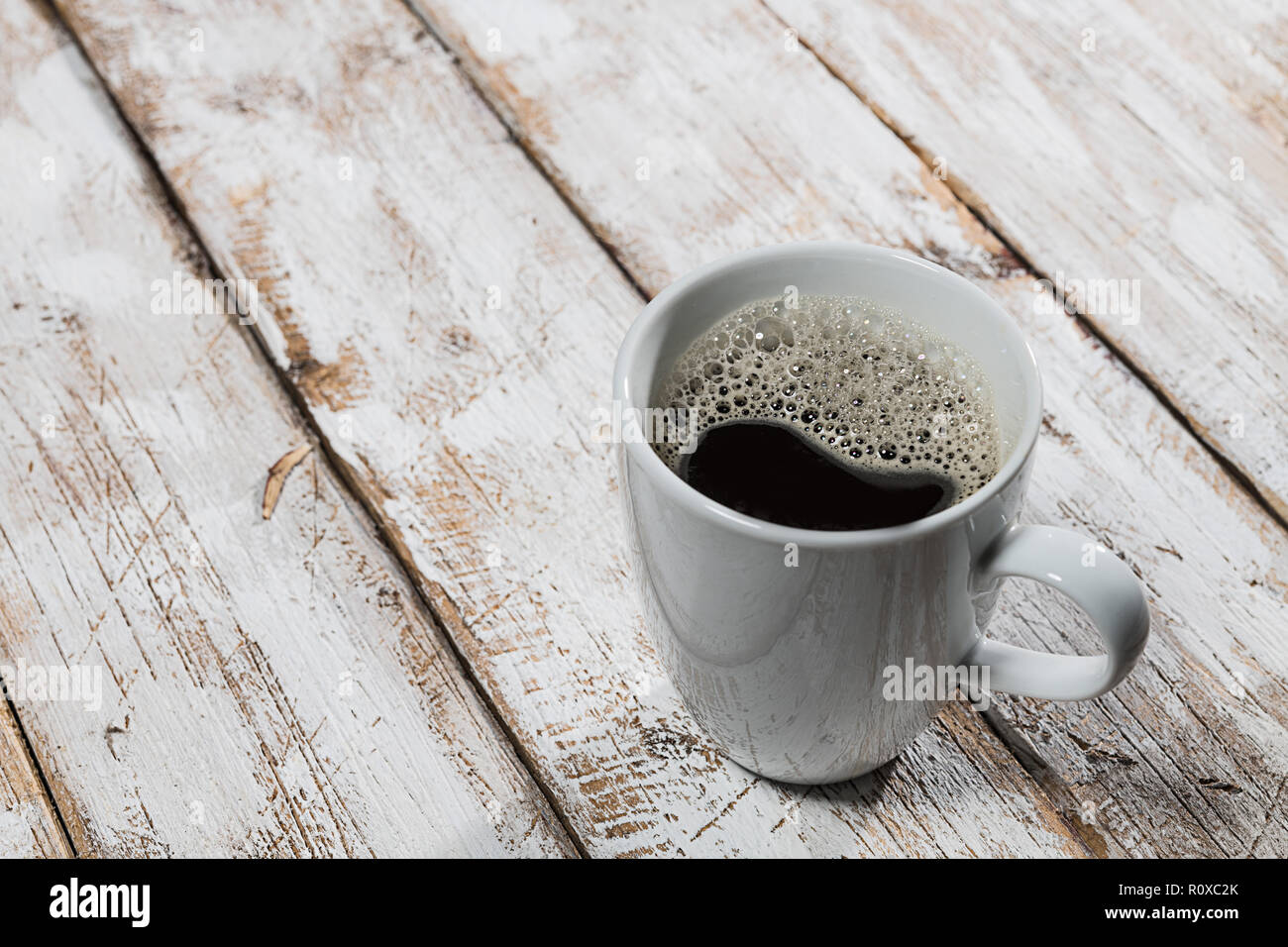 White cup with coffee on old wooden table Stock Photo
