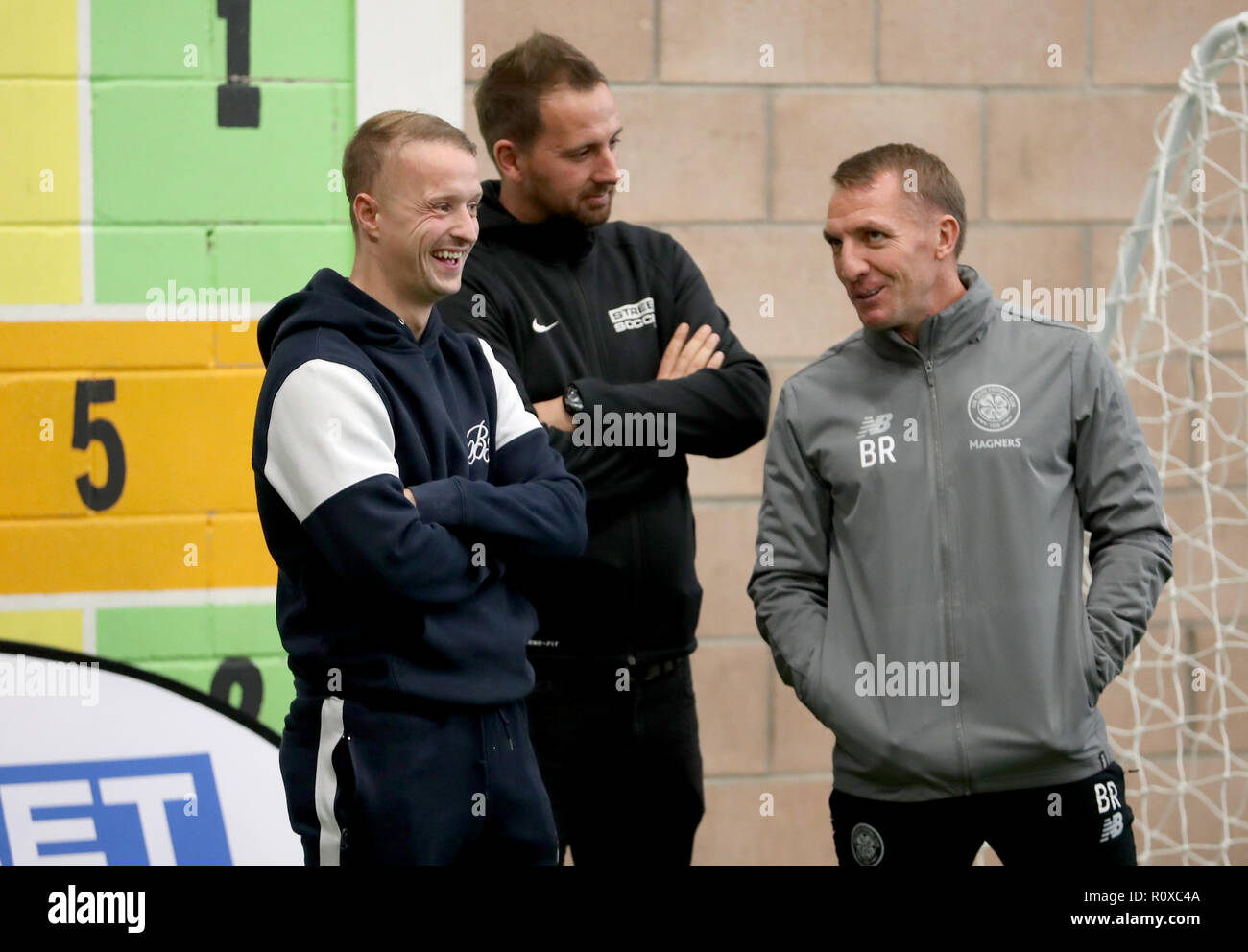 Celtic's Leigh Griffiths (left) and manager Brendan Rodgers (right) with Street Soccer founder and CEO David Duke (centre) watch the men and women Street Soccer teams during a special training session at Lennoxtown, Glasgow. Stock Photo