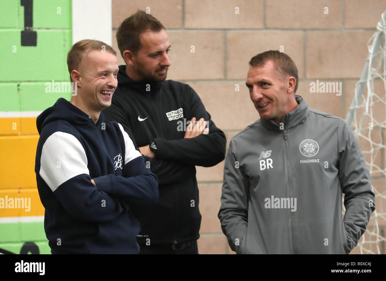 Celtic's Leigh Griffiths (left) and manager Brendan Rodgers (right) with Street Soccer founder and CEO David Duke (centre) watch the men and women Street Soccer teams during a special training session at Lennoxtown, Glasgow. Stock Photo