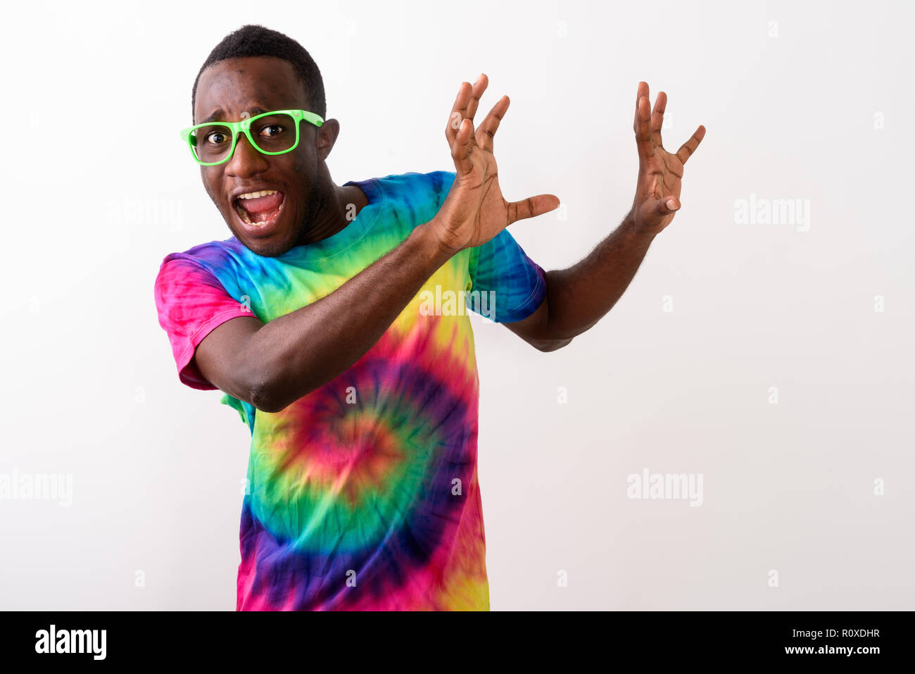 Studio shot of young scared black African man looking afraid and Stock Photo