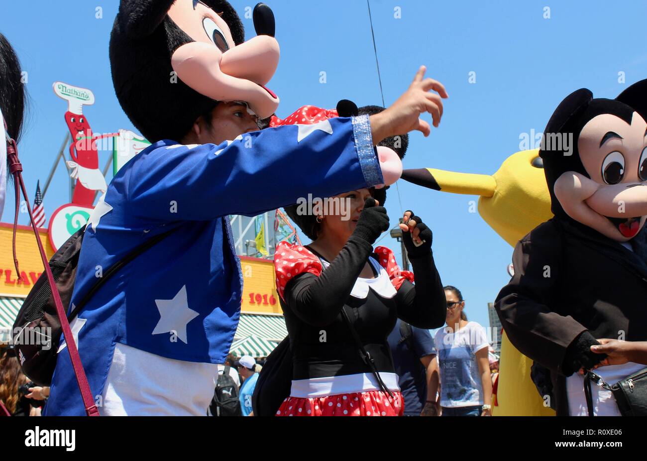 hispanic men and women dressed as cartoon characters mickey and minnie mouse and pikachu on coney island boardwalk brooklyn new york uSA Stock Photo