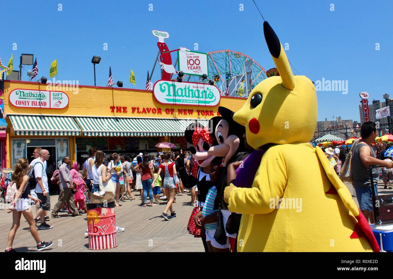 hispanic men and women dressed as cartoon characters mickey and minnie mouse and pikachu on coney island boardwalk brooklyn new york uSA Stock Photo
