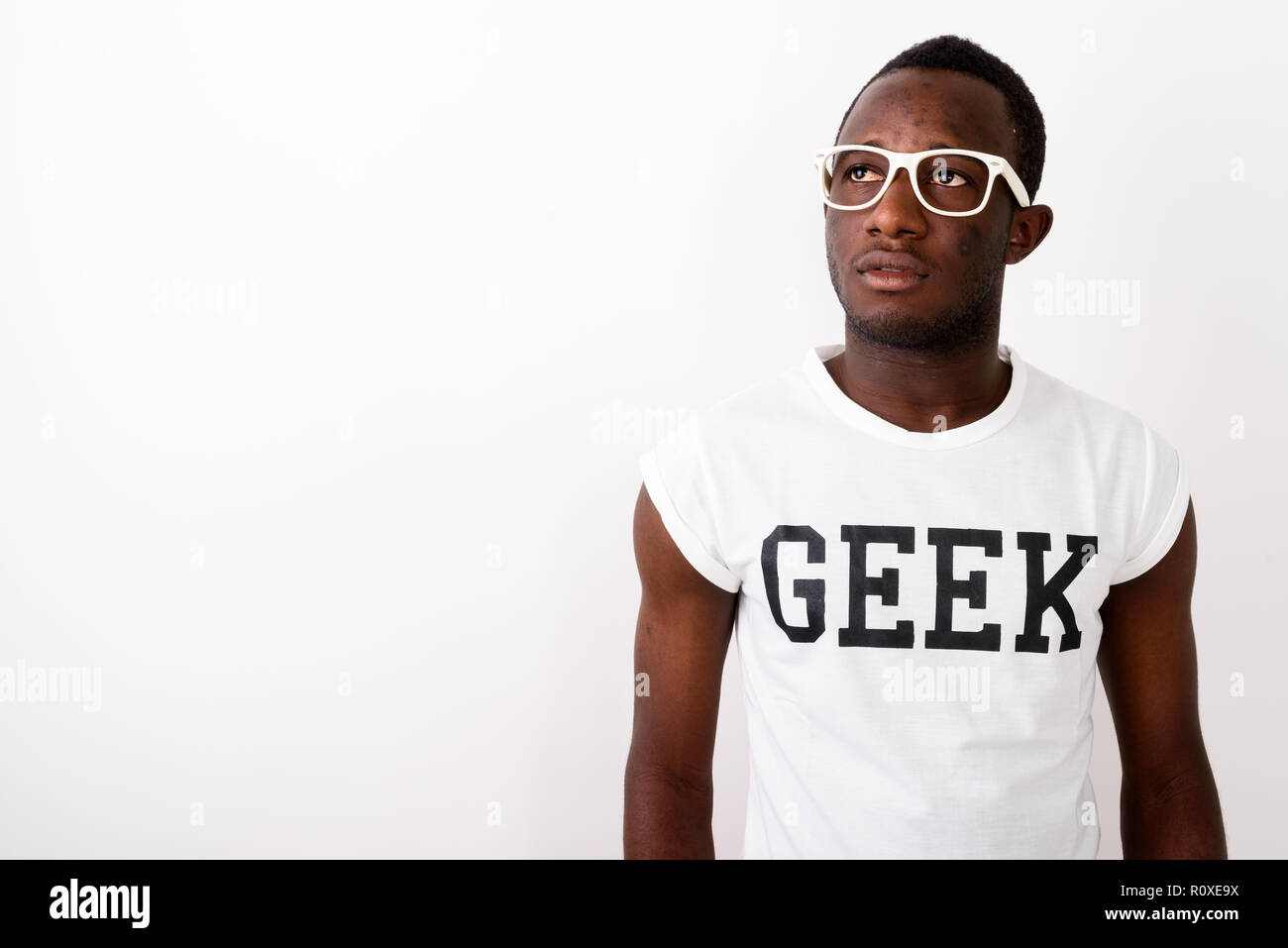 Studio shot of young black African nerd man thinking while weari Stock Photo