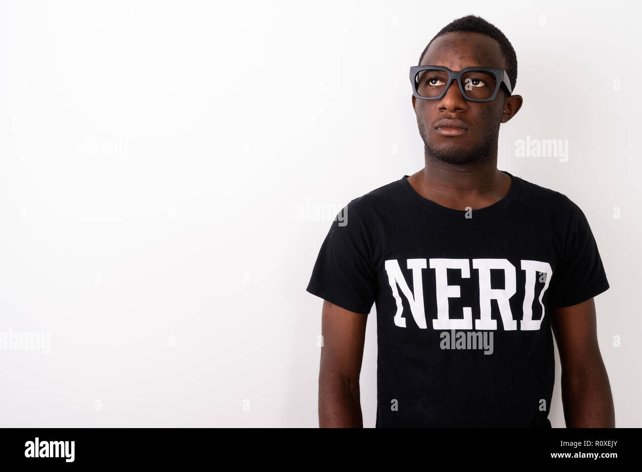 Studio shot of young black African geek man wearing Nerd shirt w Stock Photo