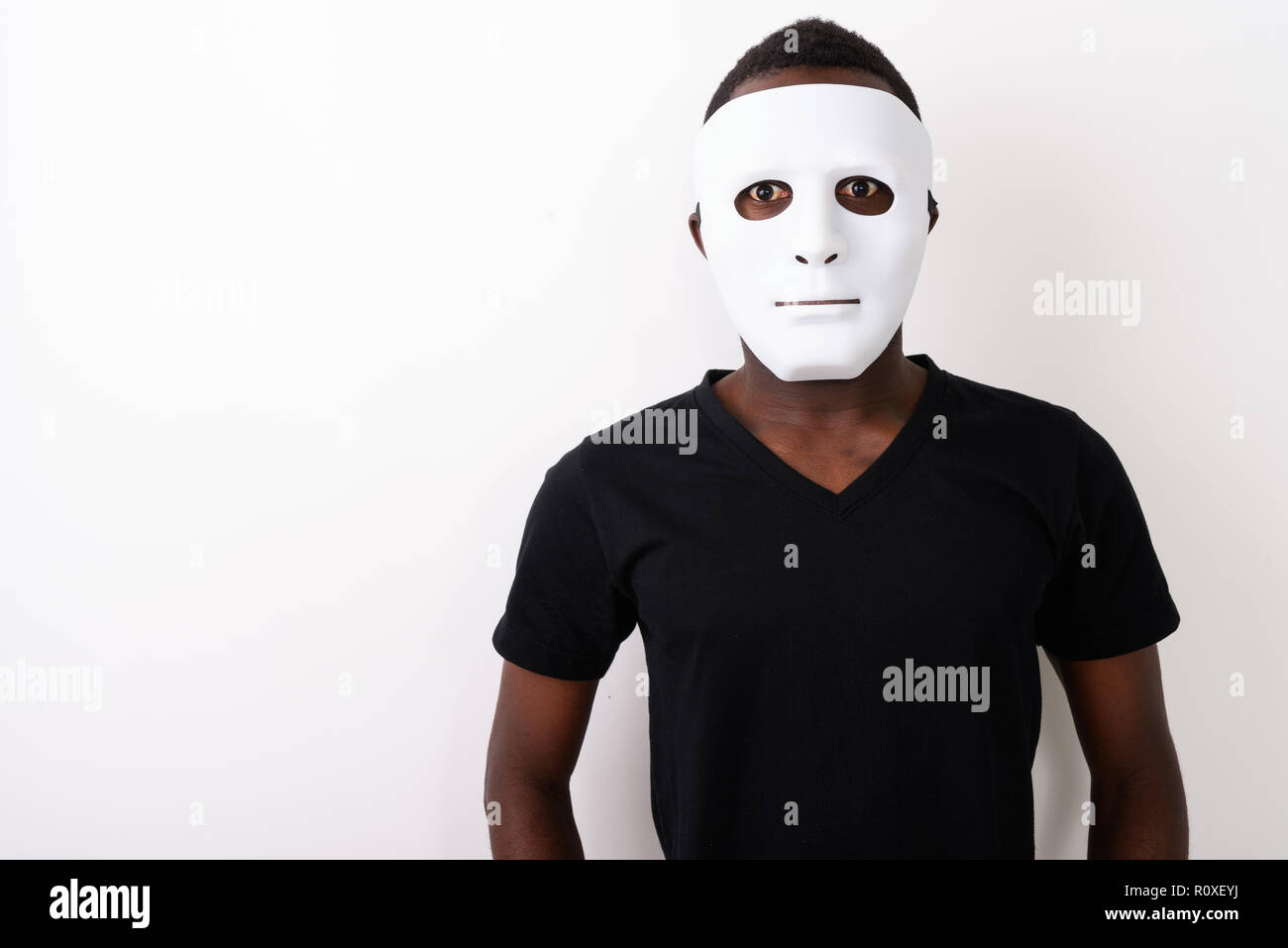 Studio shot of young black African man wearing mask Stock Photo