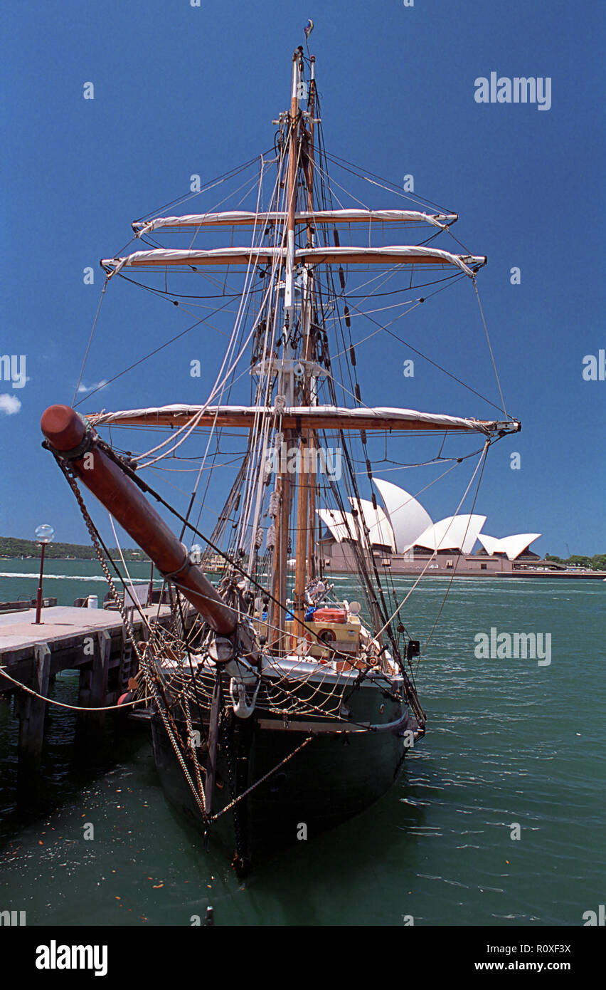 A small barquentine 'Southern Swan', moored alongside in Campbells Cove with the Sydney Opera House in the background Stock Photo