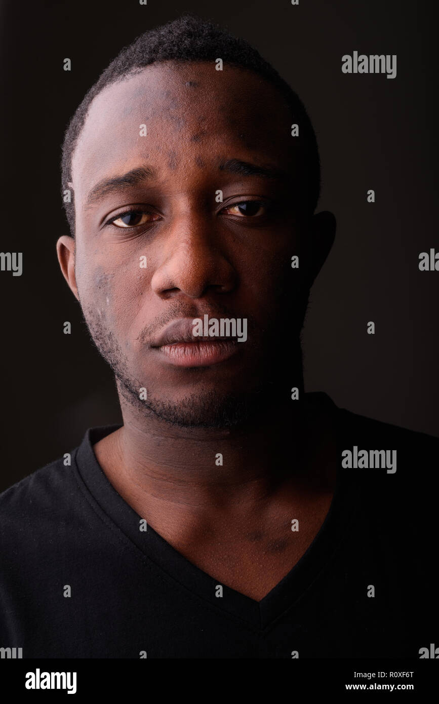 Portrait of young black African man in dark room Stock Photo