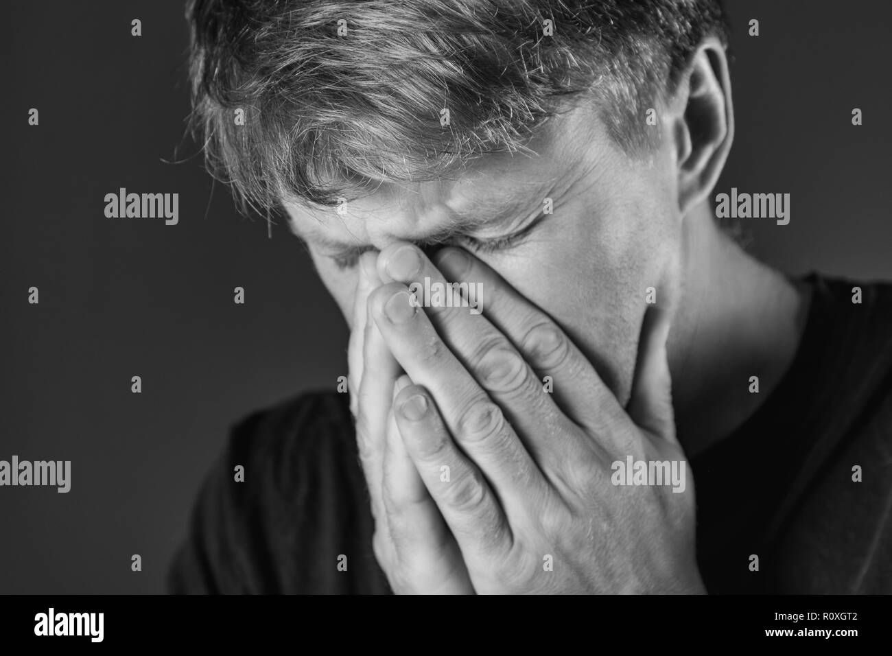 Stressed and sad man covering his face with hands Stock Photo - Alamy