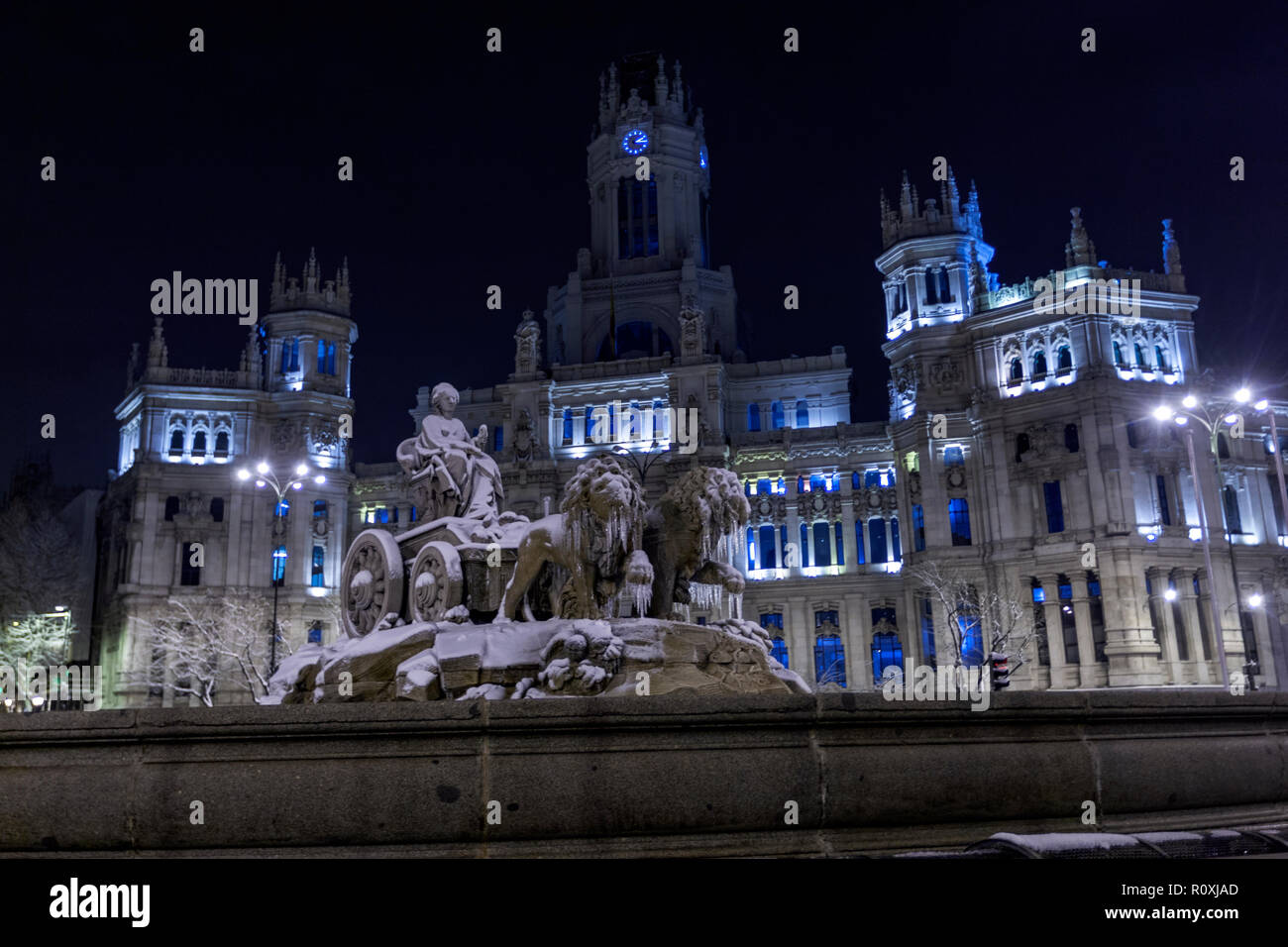 Cibeles fountain in the Plaza de Cibeles in winter with snow and icicle and the Cybele Palace (City Hall. The plaza is a landmark of Madrid, Spain Stock Photo
