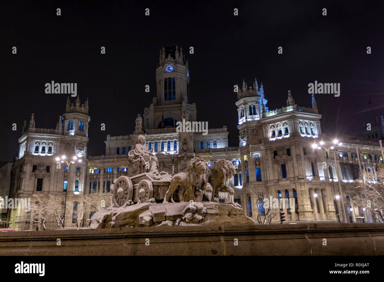 Cibeles fountain in the Plaza de Cibeles in winter with snow and icicle and the Cybele Palace (City Hall. The plaza is a landmark of Madrid, Spain Stock Photo