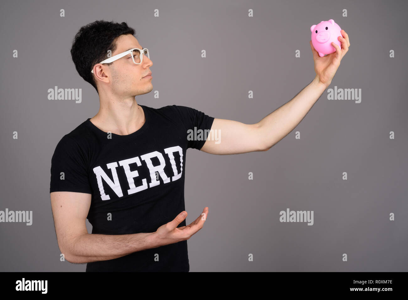 Young handsome nerd man with eyeglasses against gray background Stock Photo