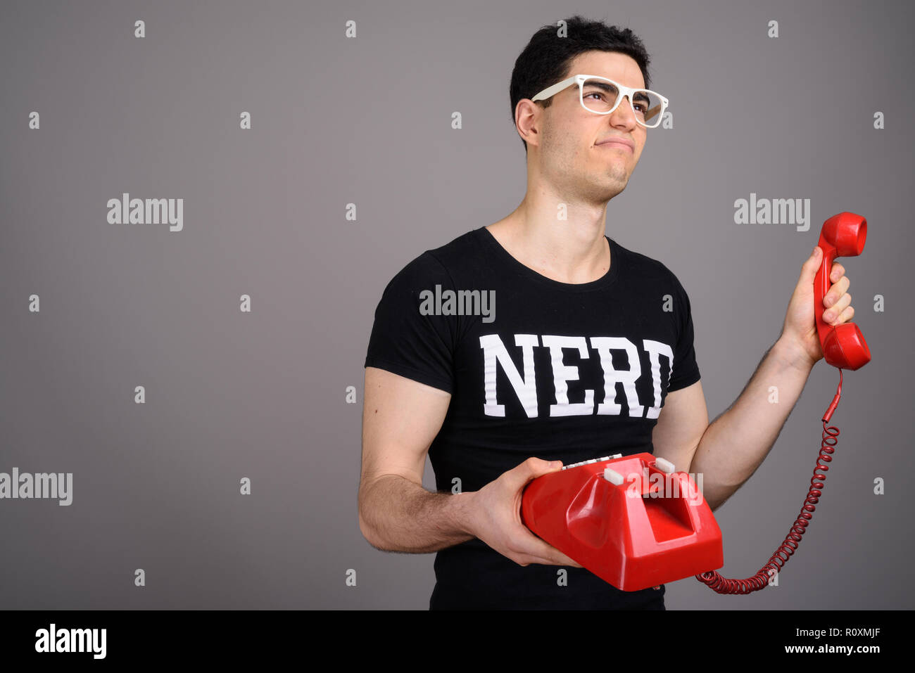 Young handsome nerd man with eyeglasses against gray background Stock Photo