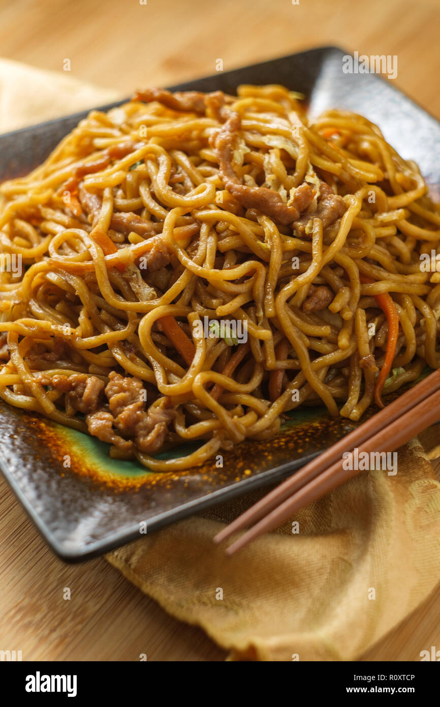 Eating Chinese pork lo mein noodles with chopsticks Stock Photo