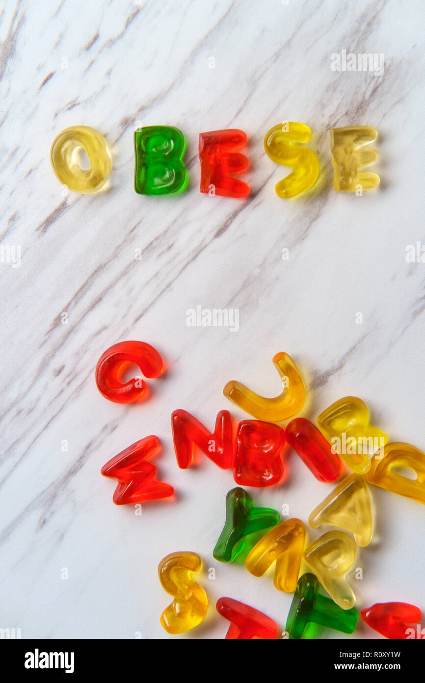 Assorted colorful gummy candy letters spell the word Obese Stock Photo