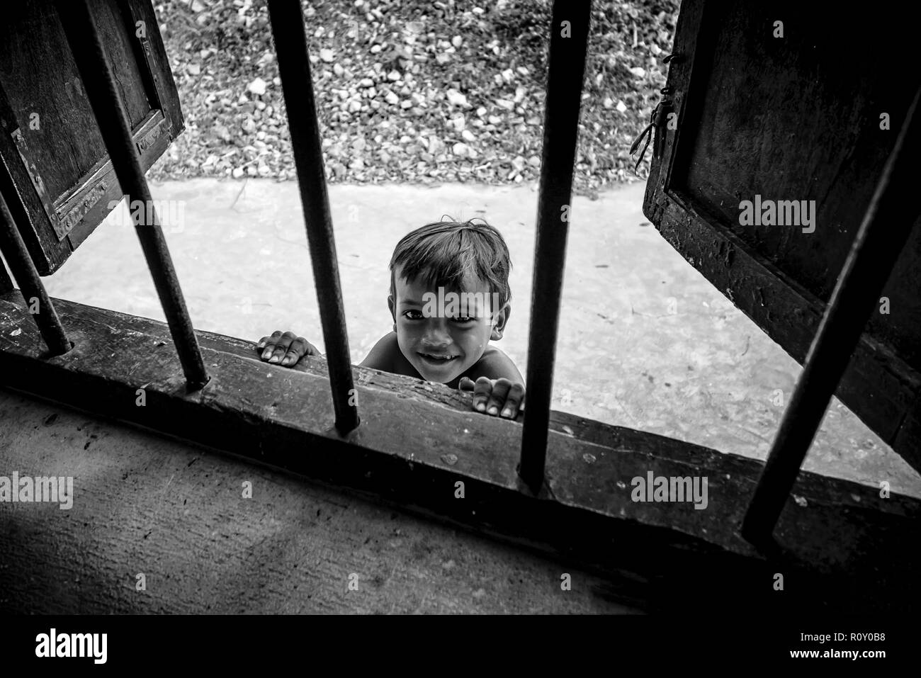 Lolei, Cambodia - January 01, 2017: A curious kid looking through window at the Wat Lolei Buddhist Temple Stock Photo