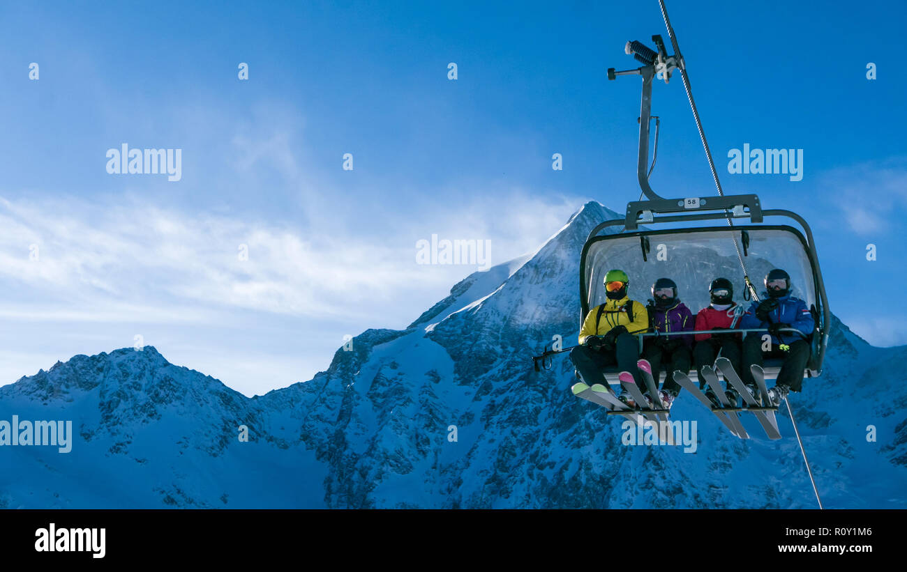 Ski holiday - family of skiers on chairlift in high Alpine ski r Stock Photo