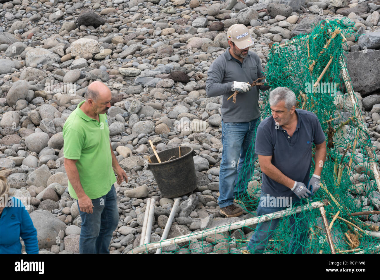 Local volunteer people cleaning the beach after a storm in Ponta do Sol, Madeira Stock Photo
