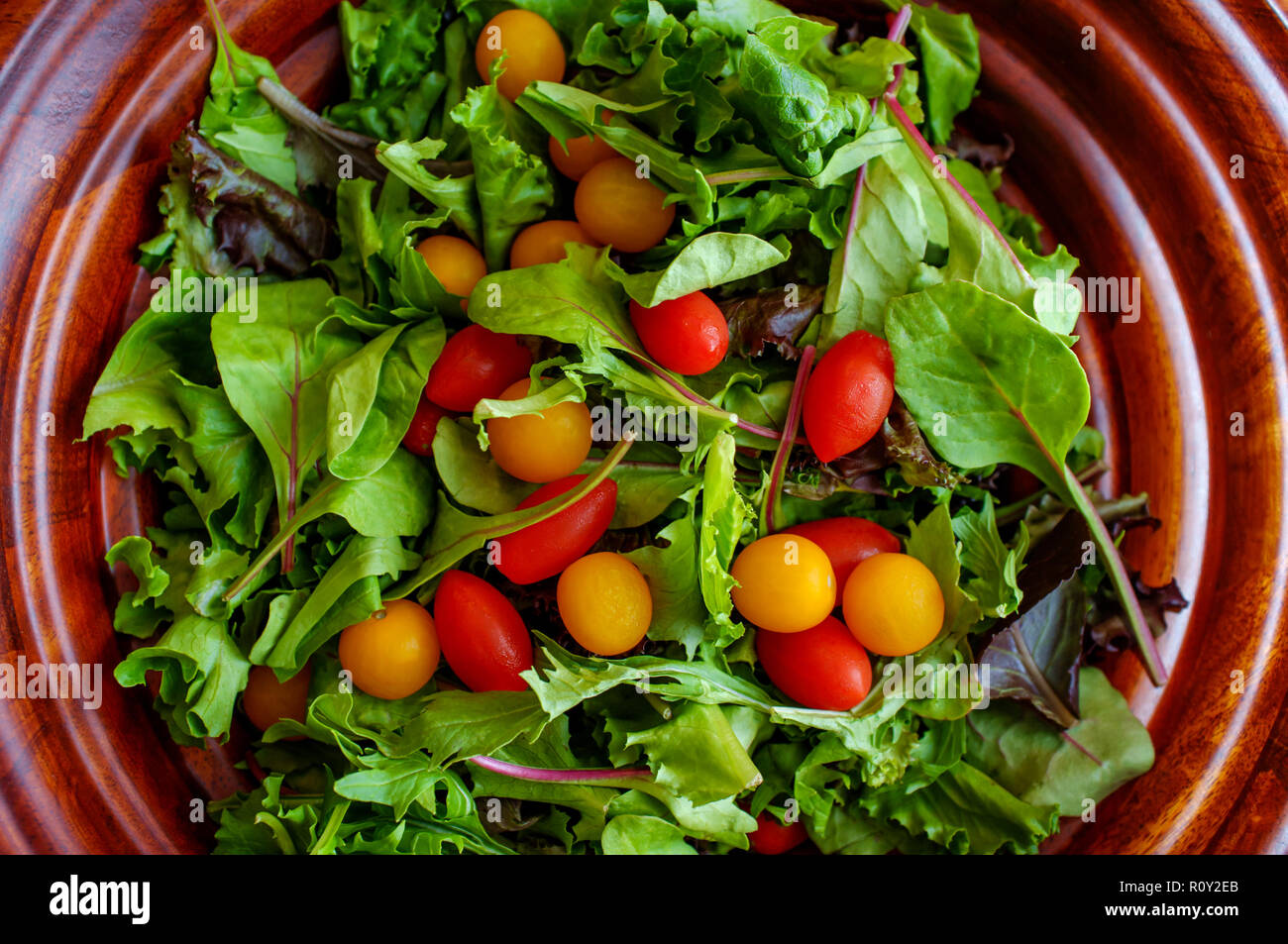Fresh organic spring mix salad with red and yellow grape tomatoes Stock Photo