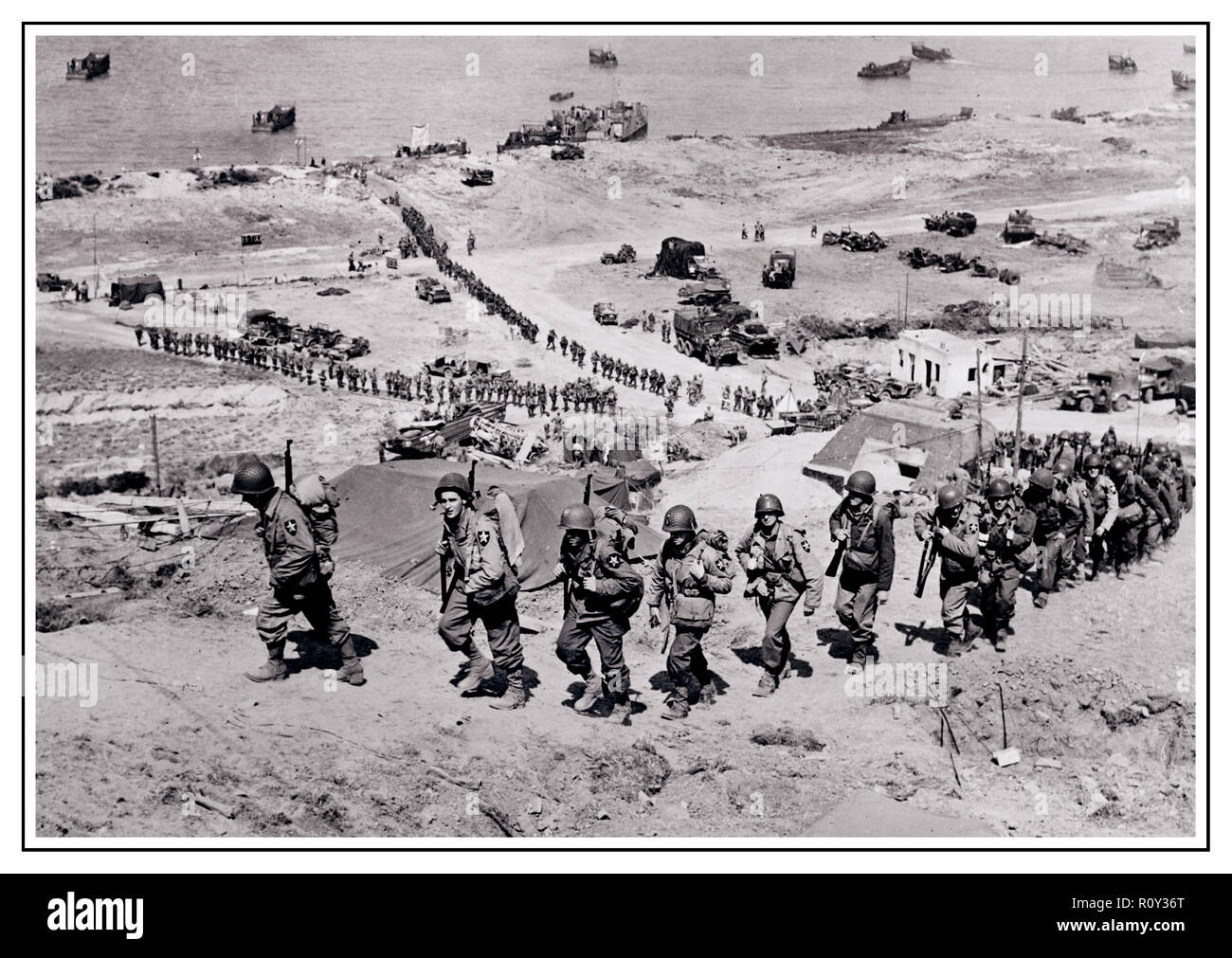 OPERATION OVERLORD D-Day +1 WW2 B&W image of the build-up at Omaha Beach Normandy. U.S. 2nd Infantry Division troops and equipment moving inland toward Saint-Laurent-sur-Mer on D-Day +1, 7 June 1944. Stock Photo