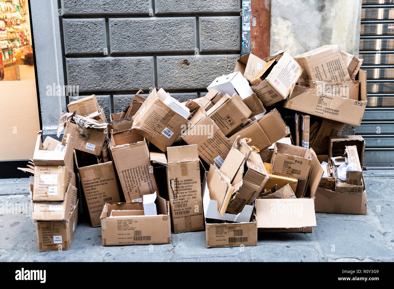 Florence, Italy - August 31, 2018: Pile, stack of many discarded empty cardboard boxes, lying on the street, sidewalk in Firenze, trash, rubbish, litt Stock Photo