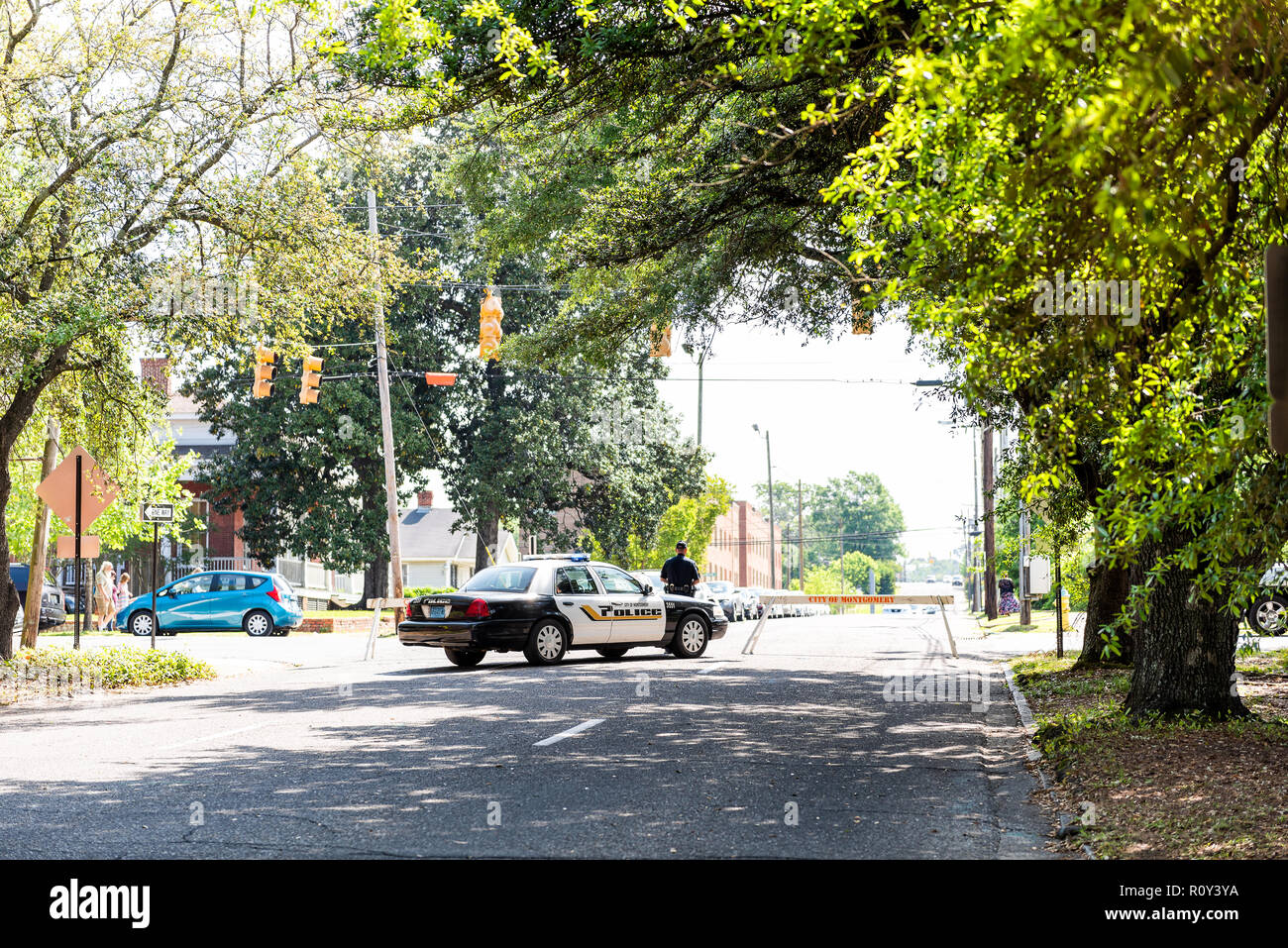 Montgomery, USA - April 21, 2018: Alabama city police officer car on street, with sign, people walking on sidewalk, blocked road, roadblock, block Stock Photo