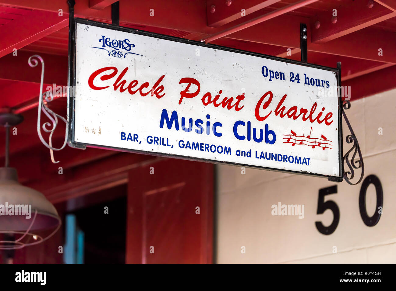 New Orleans, USA - April 22, 2018: Frenchmen street covered sidewalk in Louisiana town, city, building, sign closeup for Check Point Charlie Music Clu Stock Photo