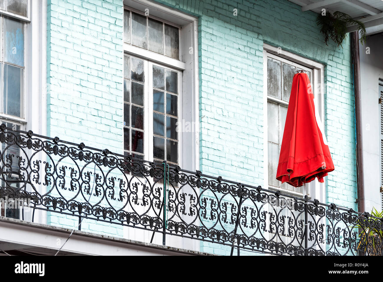 New Orleans, USA Blue colorful turquoise color painted balcony with red umbrella in downtown historic city in Louisiana Stock Photo