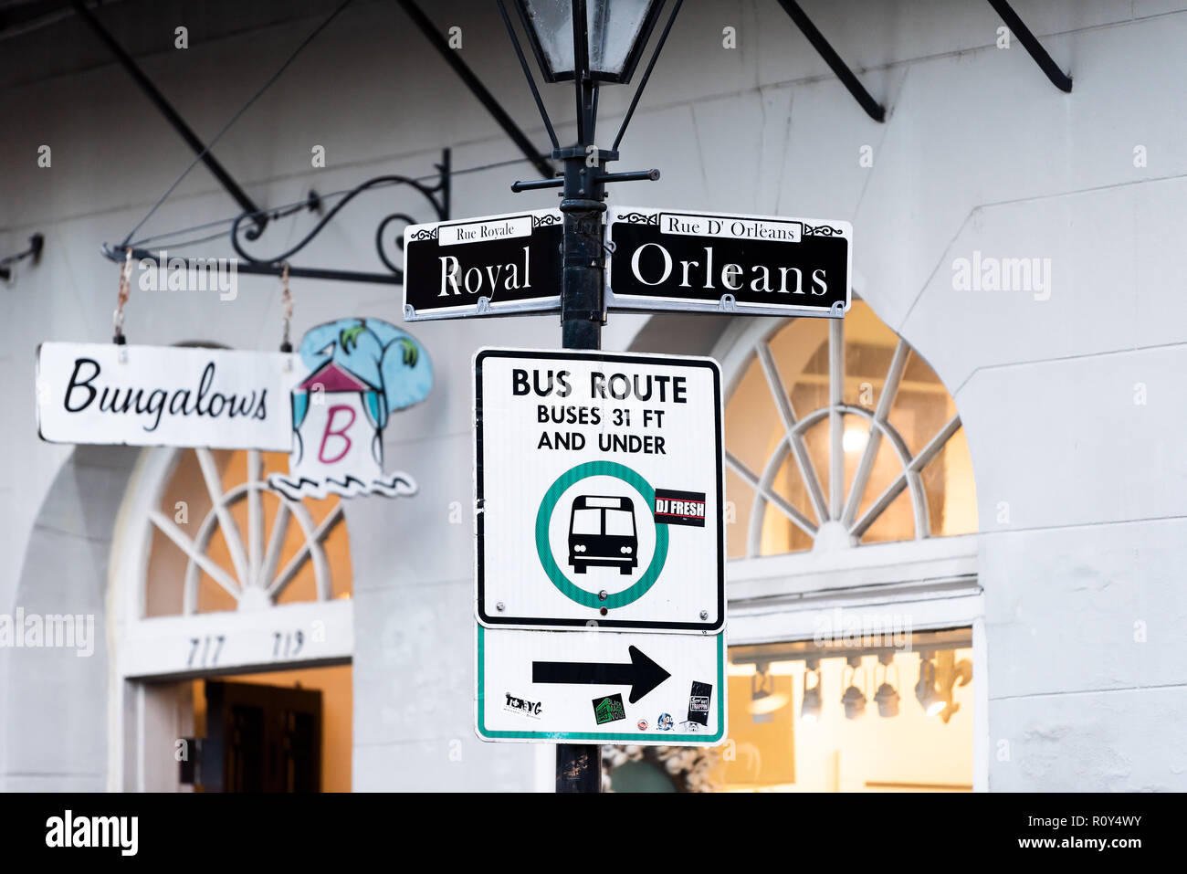 New Orleans, USA - April 22, 2018: Old town Royal Royale street intersection sign in Louisiana town, city, Bungalows store during evening, bus route Stock Photo