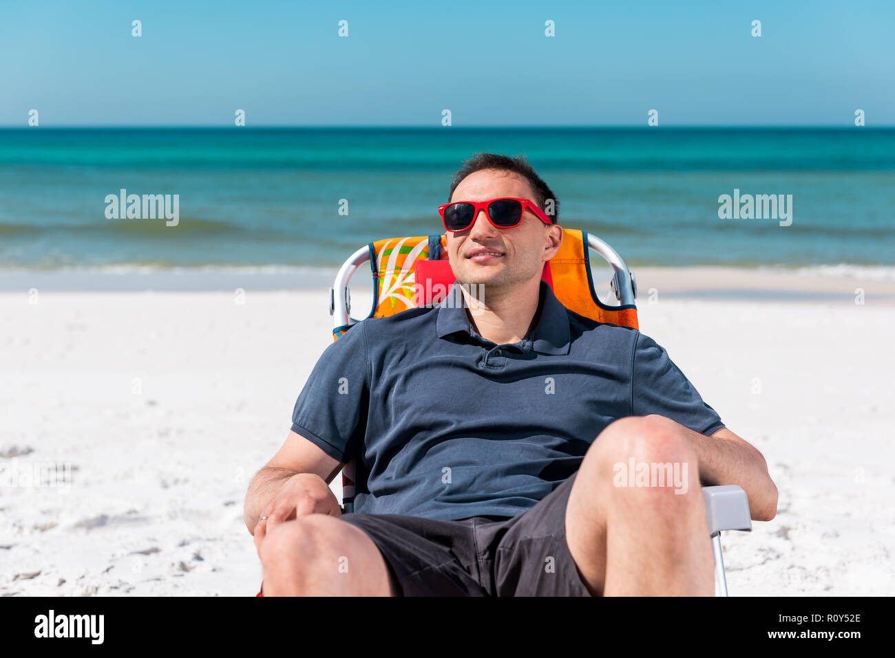 Happy Man Smiling Face Closeup Lying On Beach Lounge Chair During Sunny Day With Red Sunglasses In Florida Panhandle With Ocean Water Stock Photo Alamy