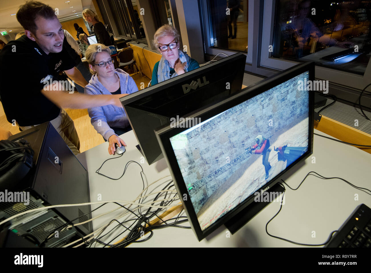 Hannover, Germany. 07th Nov, 2018. Mothers Christine Hippchen (r) and  Kerstin Sohst play the computer game Counter-Strike with computer scientist  Oliver Jathe at a LAN party for parents. The intensive immersion of