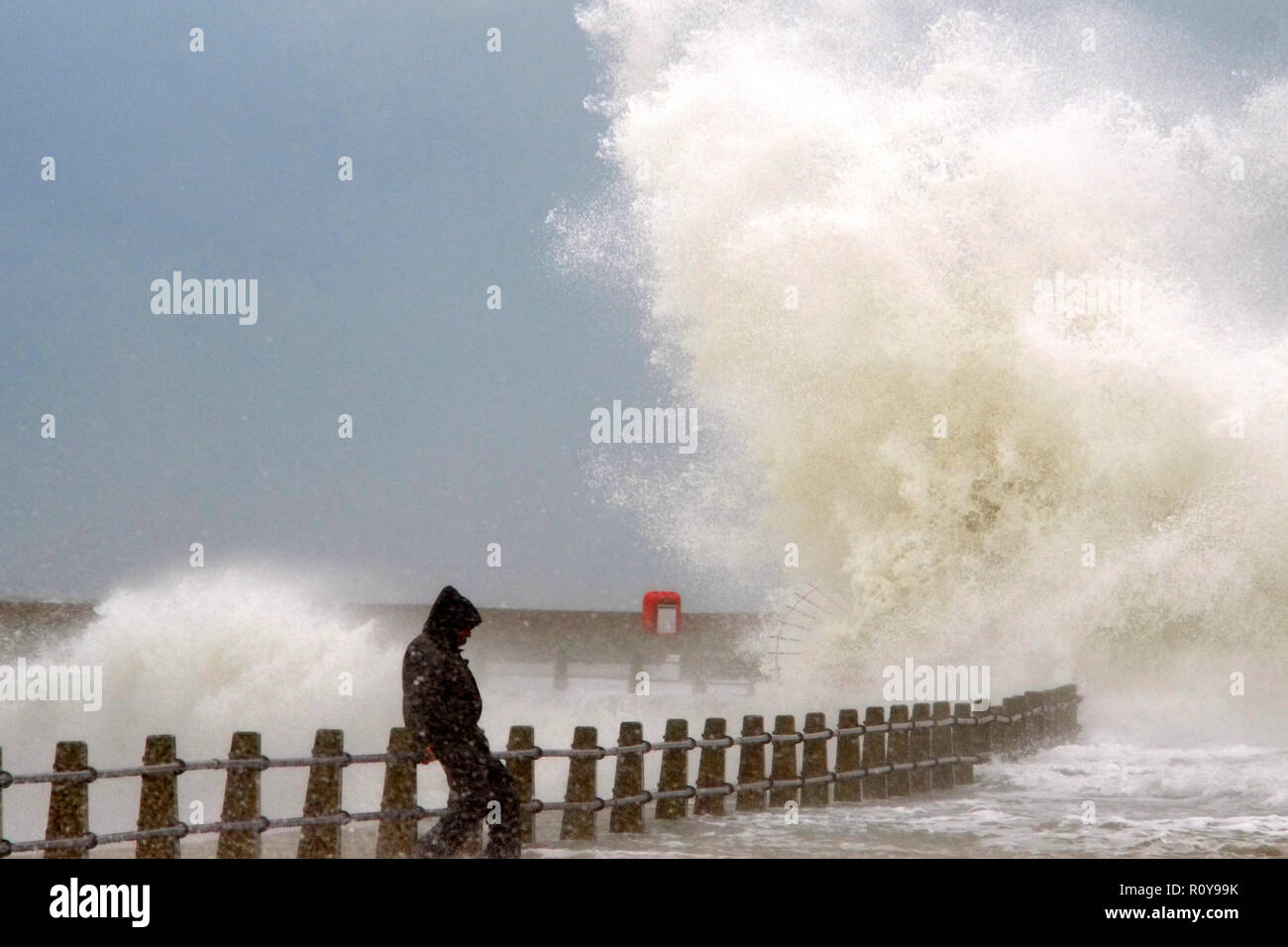 Newhaven, East Sussex. UK. 7th November 2018. A man risks his life dodging huge waves in Newhaven Harbour, East Sussex, as strong winds whip up the seas at high tide. © Peter Cripps/Alamy Live News Stock Photo