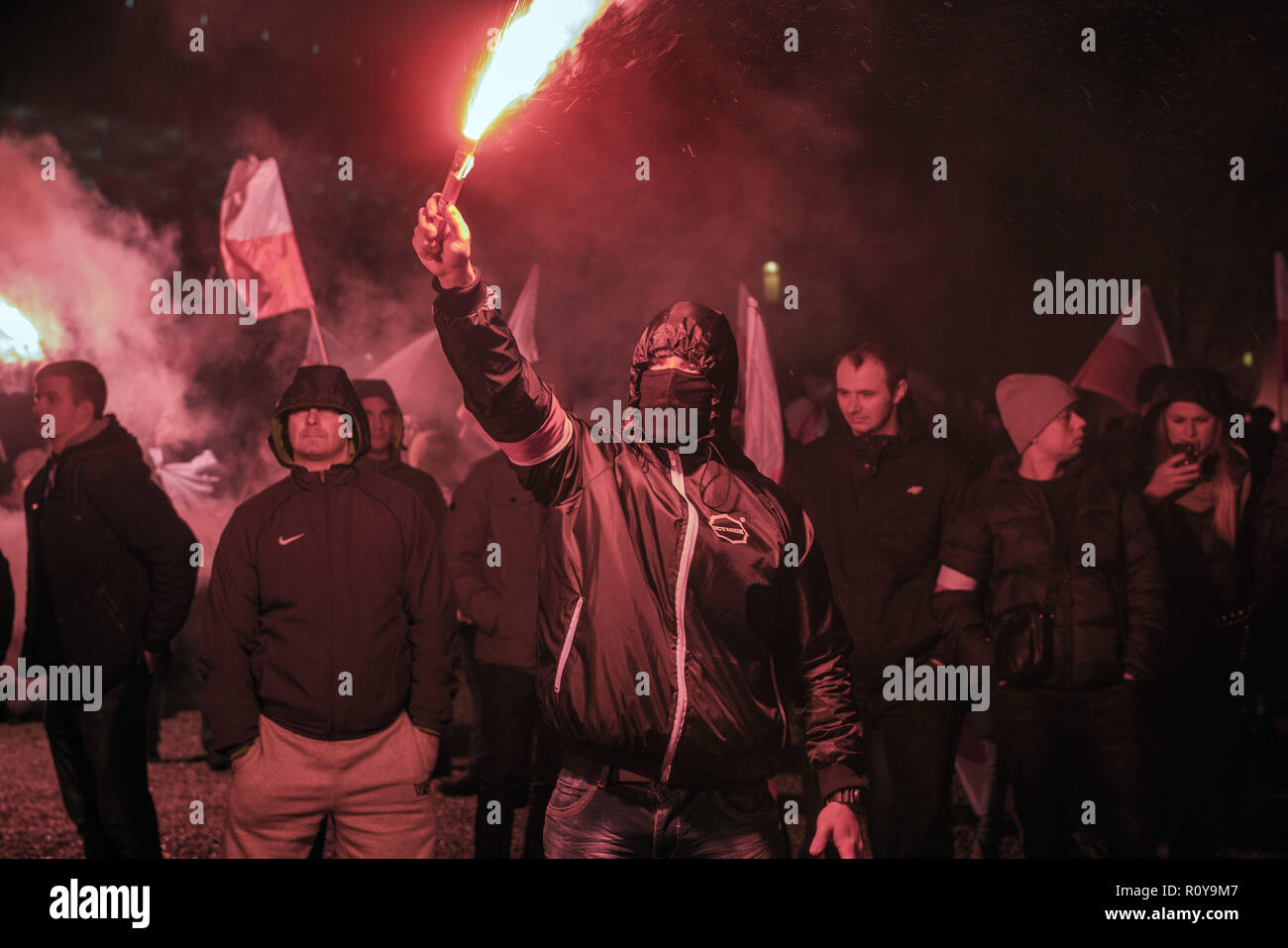 November 11, 2017 - Warsaw, mazowieckie, Poland - A masked nationalists seen burning flairs on the Independence Day during the demonstration.Last year about 60,000 people took part in the nationalist march marking Poland's Independence Day, according to police figures. The march has taken place each year on November 11th for almost a decade, and has grown to draw tens of thousands of participants, including extremists from across the EU.Warsaw's mayor Hanna Gronkiewicz-Waltz has banned the event. Organizers said they would appeal against the decision, insisting they would go ahead with t Stock Photo
