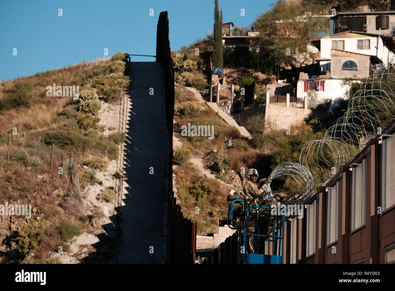 Nogales, Arizona, USA. 7th Nov, 2018. The US Army laying barbed wire on top of the border wall at international border station in Nogales, Arizona. The soldiers are part of the 5,000 troops that President Trump has ordered the Pentagon to dispatch to the Southwest border to assist the US Border Patrol in advance of the possible arrival of caravans of Central American migrants. Credit: Christopher Brown/ZUMA Wire/Alamy Live News Stock Photo