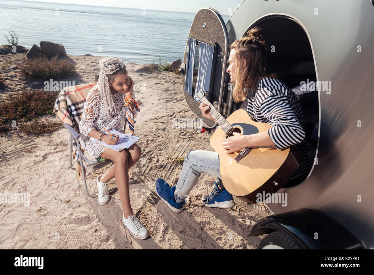 Woman with dreadlocks falling in love while listening to her man singing Stock Photo