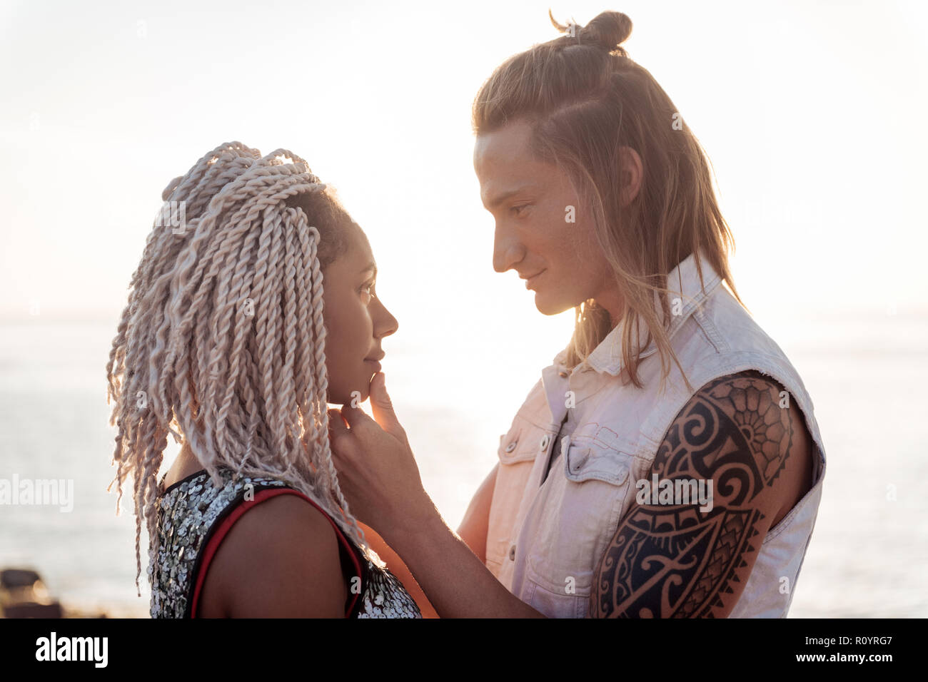 Woman with dreadlocks falling in love with handsome man looking at him Stock Photo