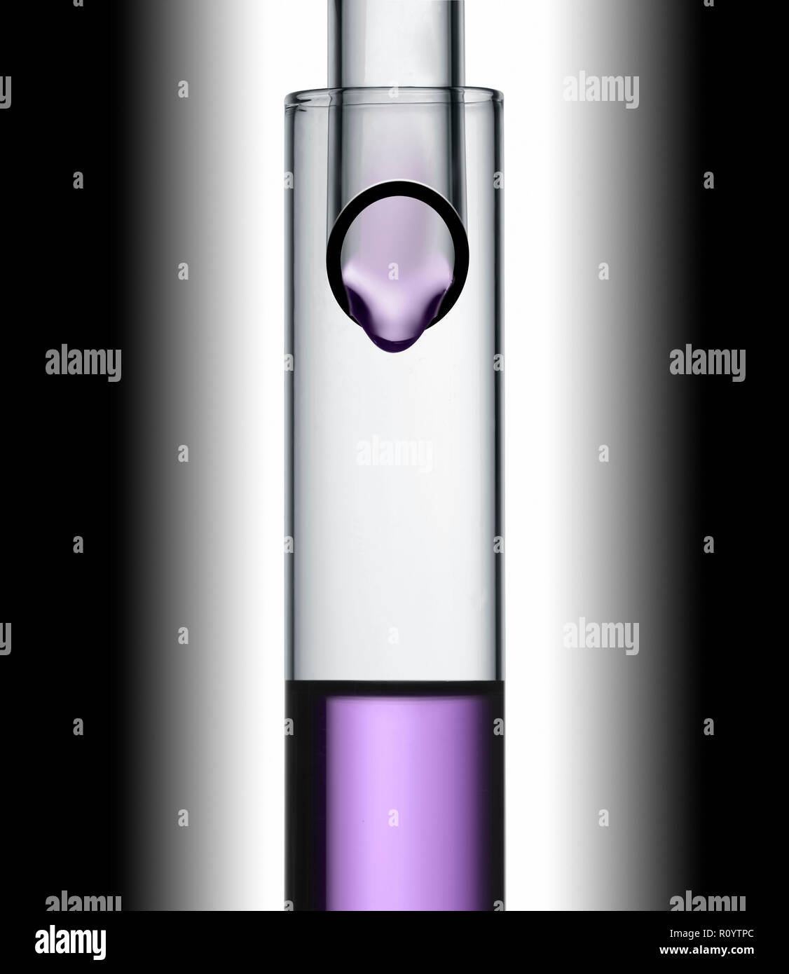 Purple beauty treatment liquid droplet dropping from one test tube into another, studio still life Stock Photo