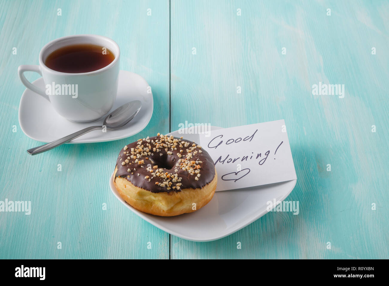 Donuts on saucer with note Good morning Stock Photo