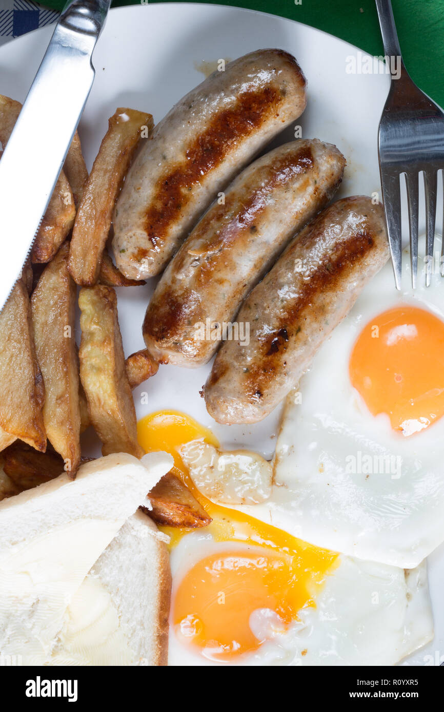 Classic British supper of Sausage, egg and chips with white sliced