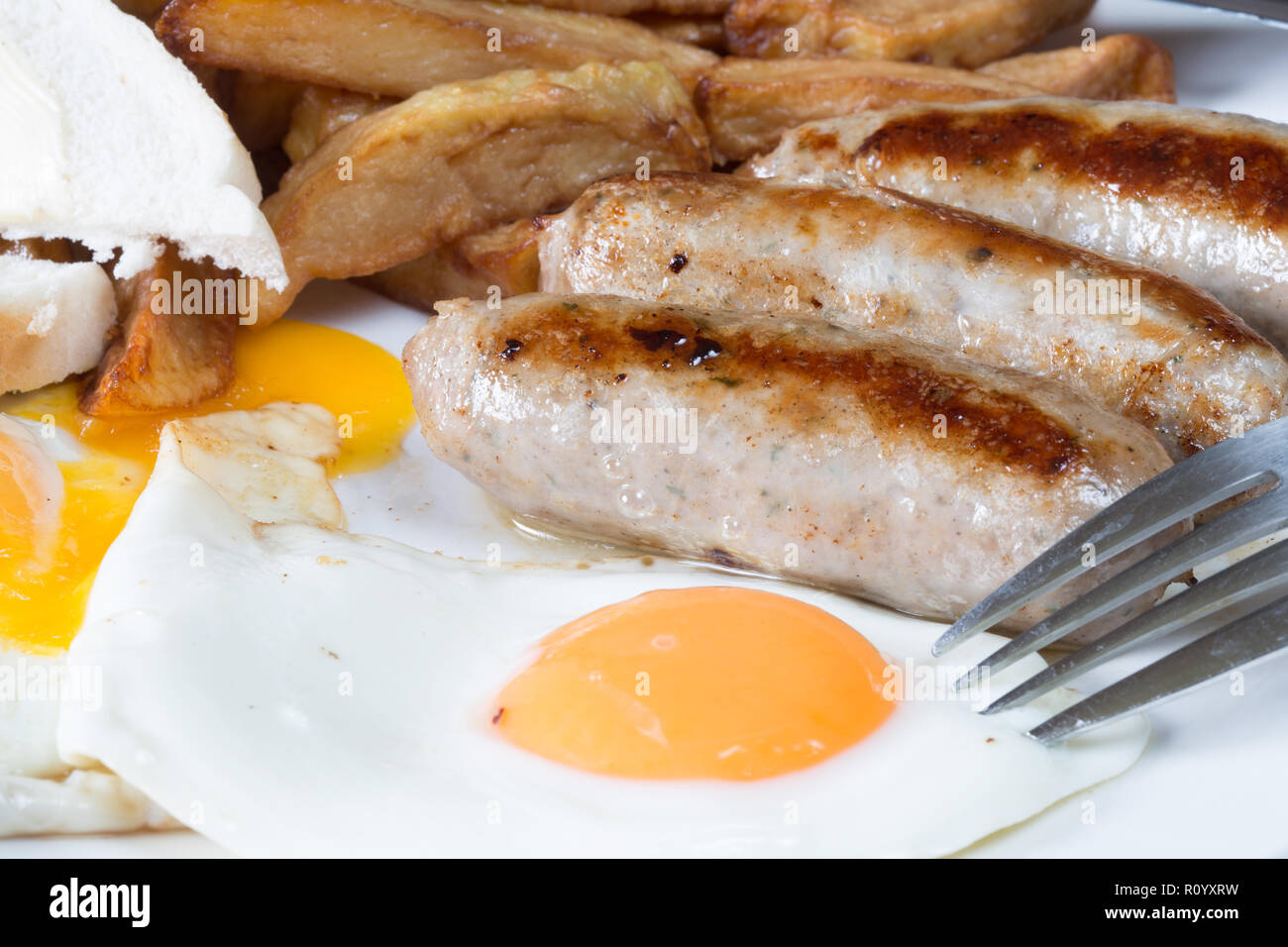 Classic British supper of Sausage, egg and chips with white sliced