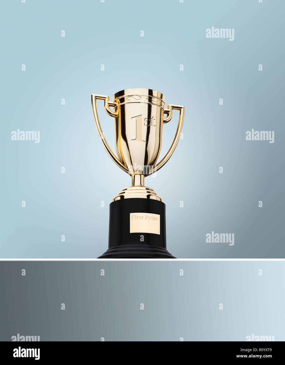First prize gold cup trophy on table against grey background Stock Photo