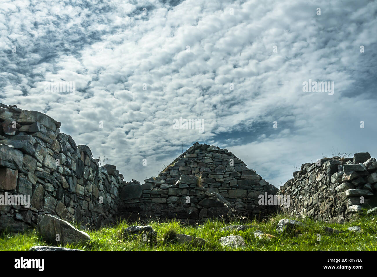 View of dramatic sky and derelict Hebridean croft house on the coast of the west side of Lewis Stock Photo