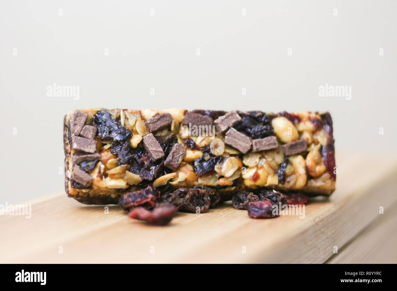 Healthy, natural granola bar with oats, nuts, and fruit sitting wooden