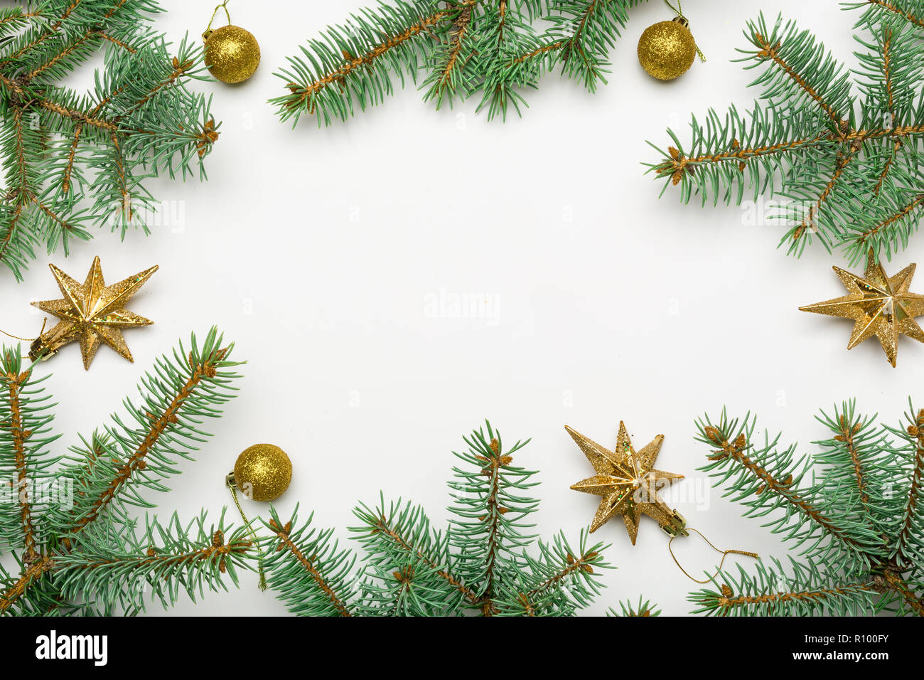 Holiday frame of Christmas decorations on white background with fir branch,  gold and red balls, stars. Elegant New Year`s snowy card Stock Photo - Alamy