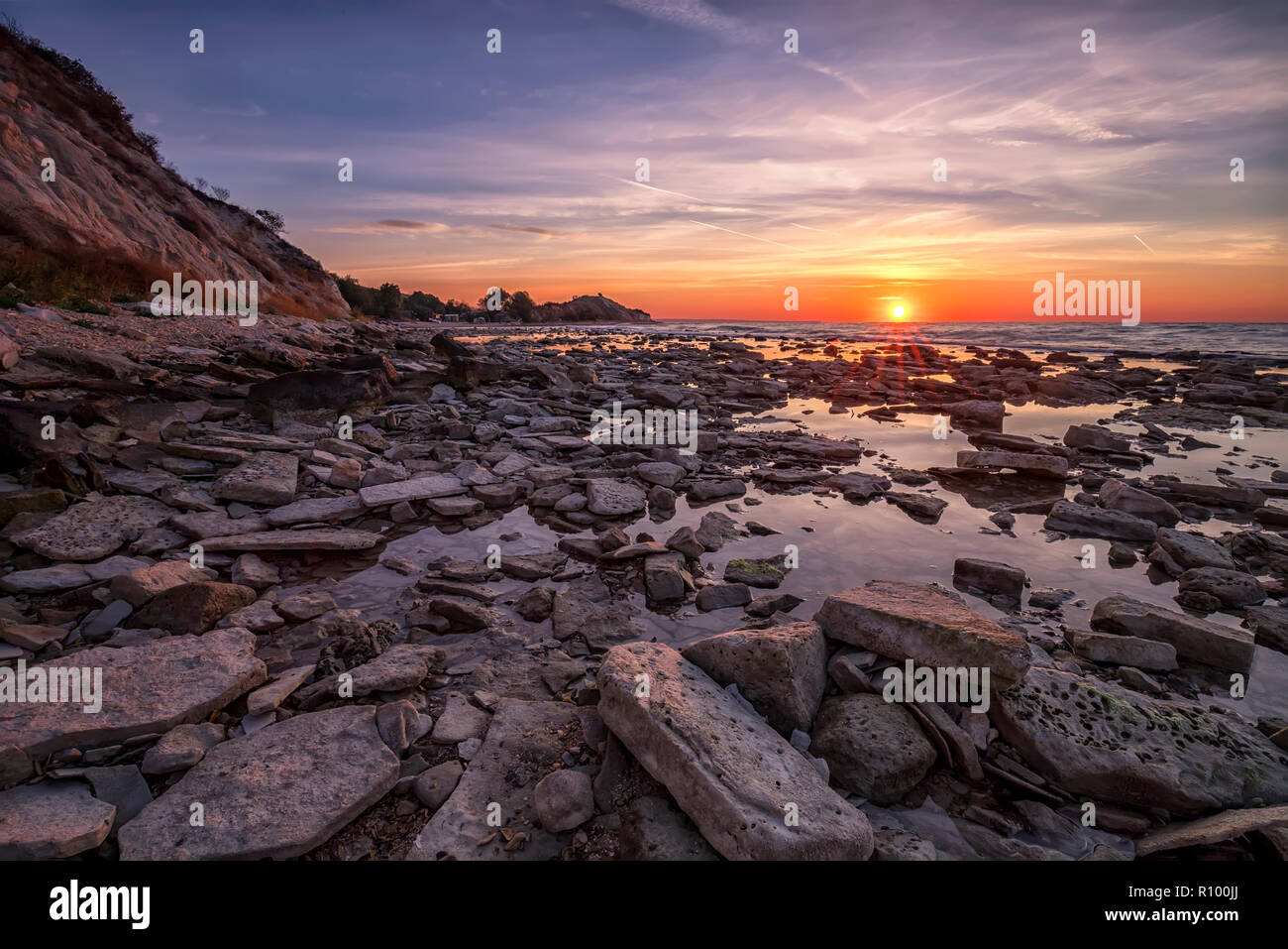 Amazing sunrise over the rocky coast sea Stock Photo - Alamy