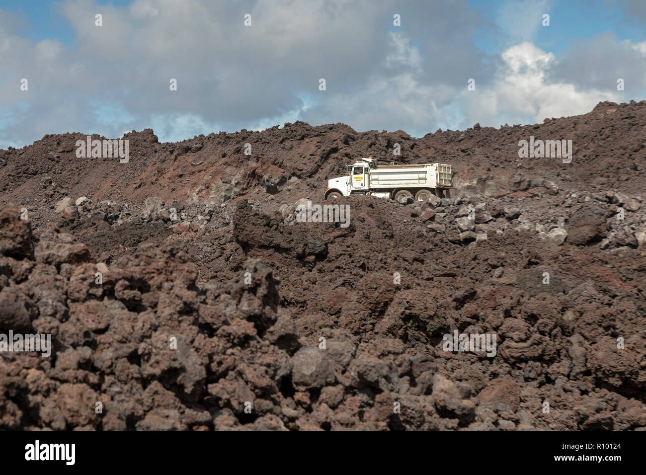 Pahoa, Hawaii Trucks traverse a road being built on cooled lava from the 2018 eruption of the