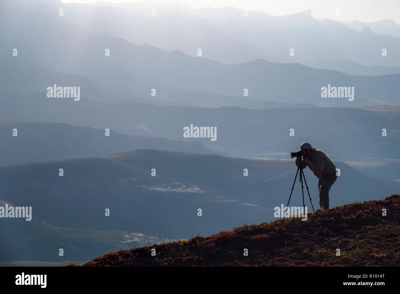 Silhouette of a lone photographer with camera and tri-pod shooting on the hills of Witsieshoek, Drakensberg, Kwazulu-Natal Province, South Africa Stock Photo