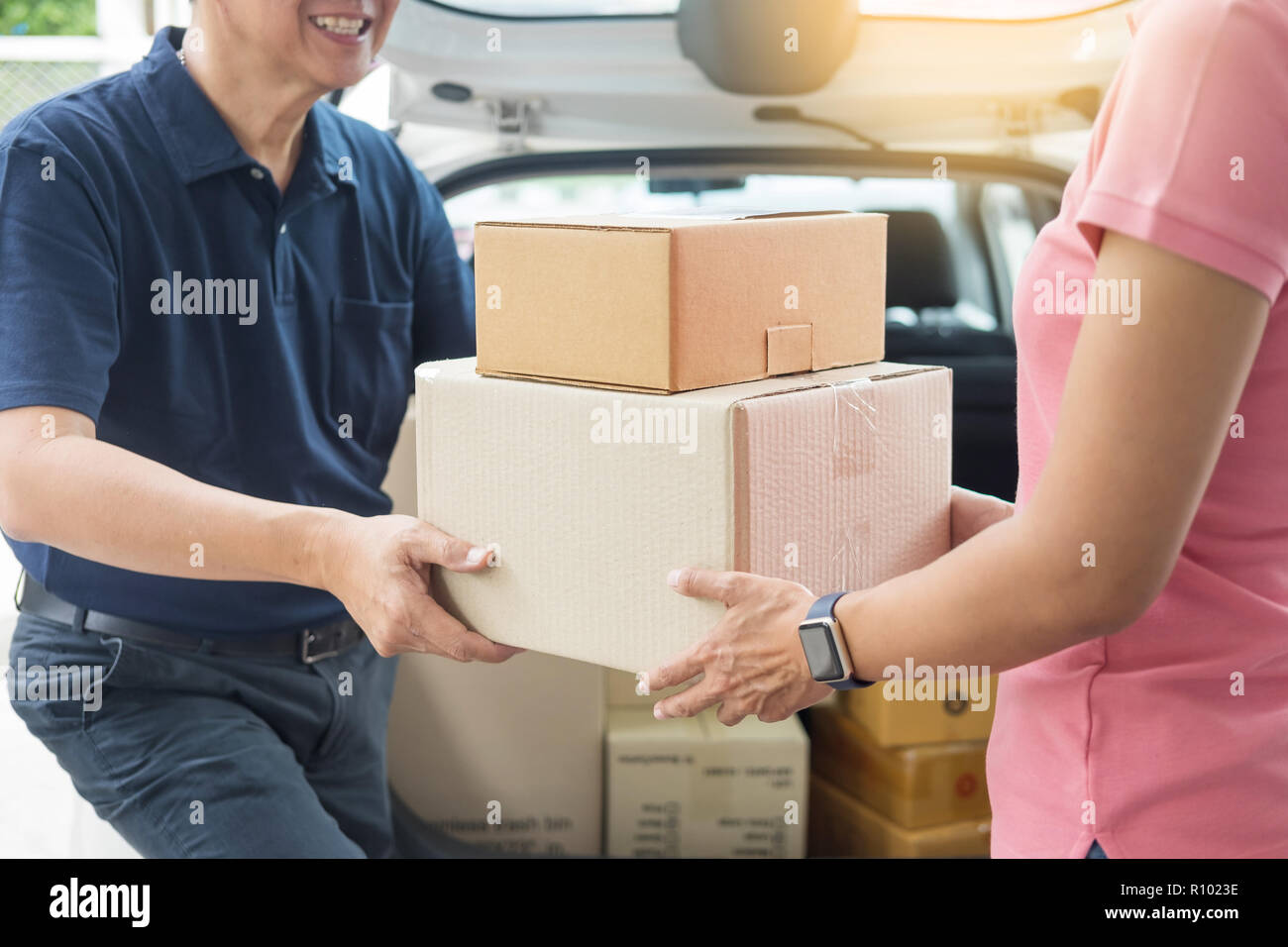 Woman Receiving Parcel Cardboard Box From Delivery Man Carrying