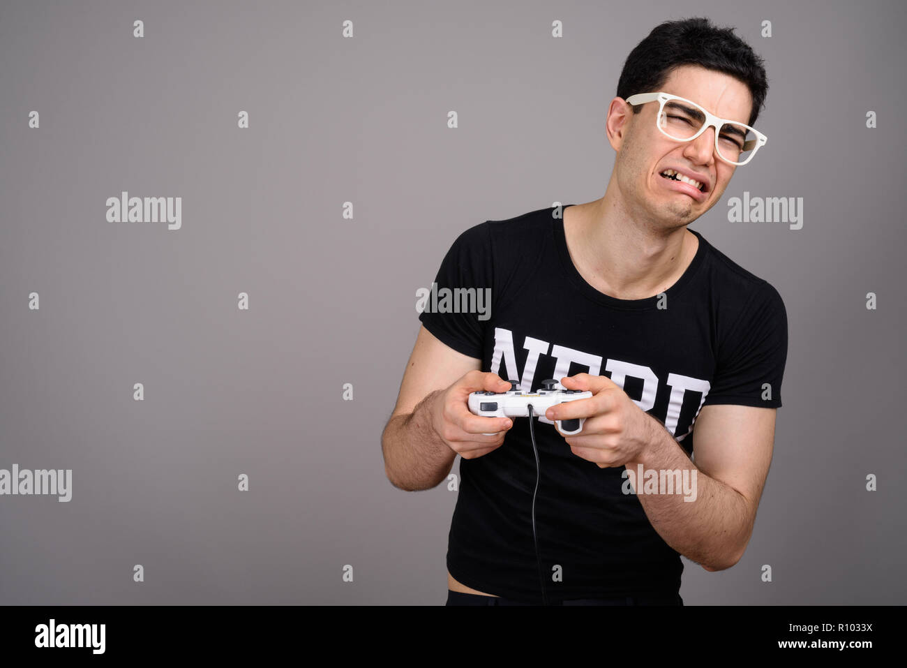Young handsome nerd man with eyeglasses against gray background Stock Photo