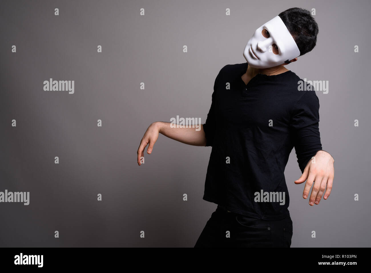 Portrait of young handsome man against gray background Stock Photo