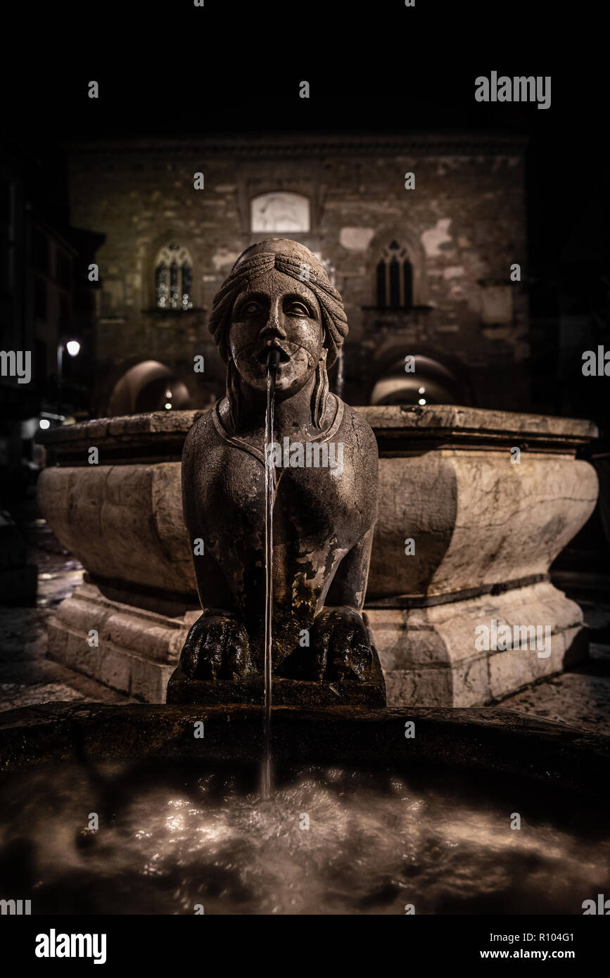 Night image of the fountain detail of Piazza Vecchia, the Sphinx of the Contarini fountain in the center of the square in Bergamo Alta, historic city Stock Photo